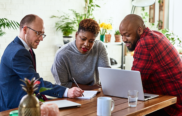 Couple and their advisor at a table, discussing options.